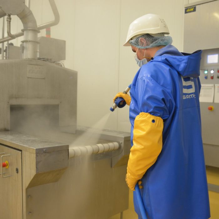 Agent nettoyant une machine agroalimentaire au jet sous pression.