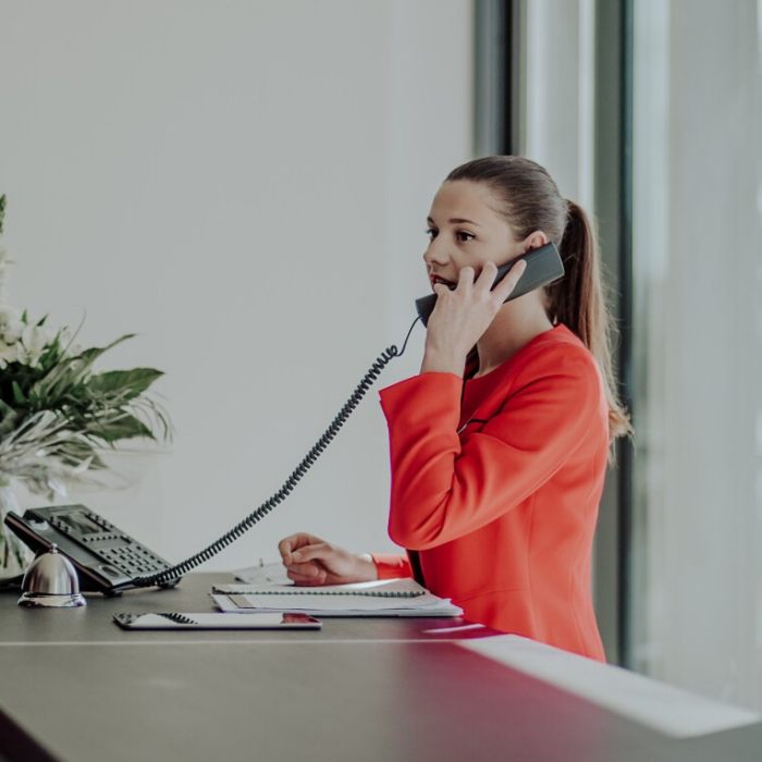 Femme hôtesse répond au téléphone à l'accueil