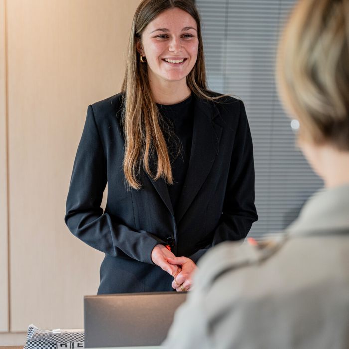 femme hôtesse d'accueil souriante face à une cliente