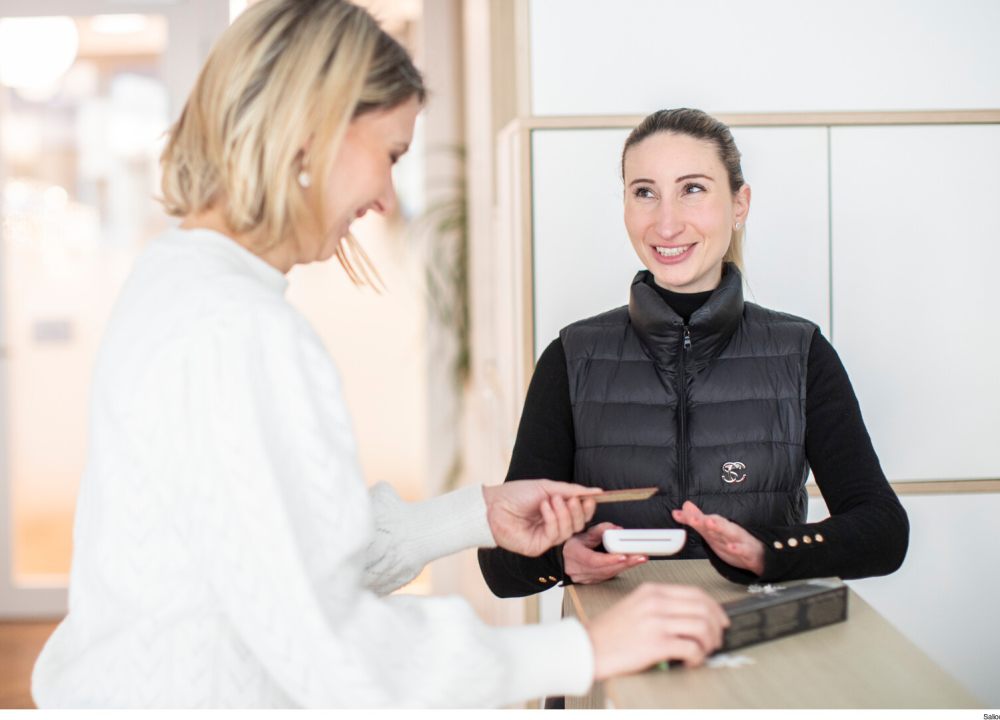 hôtesse femmes avec femme blonde réalise paiement